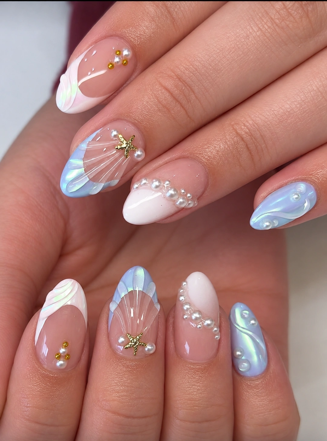 Pearl Tide manicure with blue seashell accents and pearls